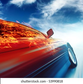 Burning Car In Motion Over Blue Sky Background