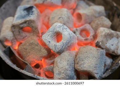Burning charcoal briquettes glow red in a metal container. - Powered by Shutterstock - Get 15% off with code: PIKWIZARD15