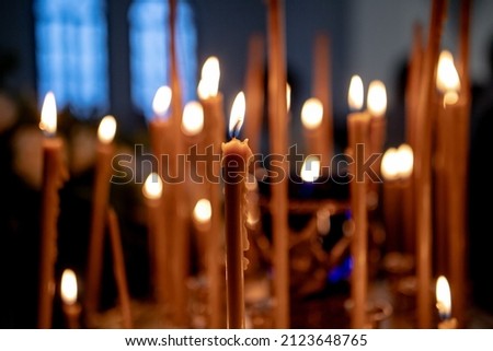Burning church candles in a gilded candlestick in a temple in the dark