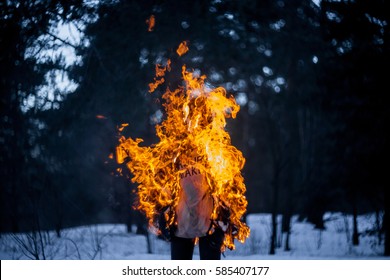 Burning clothing per person. A burning silhouette of a man. Image of a man on fire. Man on Fire. stuntman working on the fire. surrealism theme. Close-up portrait of a burning man.