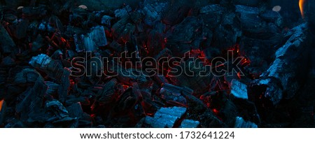 Burning coals in the dark, smoldering coal. Bright red sparks of fire. Background.