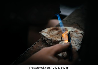 Burning details of jewelry on a stone with a gas burner. Home workshop, handmade. Close up, selective focus - Powered by Shutterstock