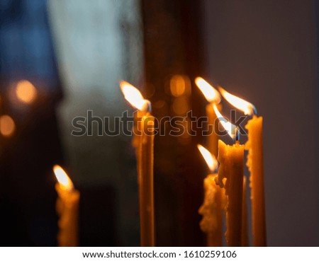 Burning in the dim light of candles in the Christian Church.