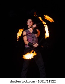 Burning Energy. Handsome Man Juggle Flaming Batons. Fire Juggling. Fire Energy. Energetic Twirling. Flame And Sparks. Night Performance. Amusement Show. Light Up And Juggle.