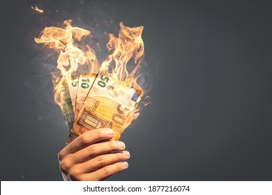 Burning Euro banknotes held by a hand