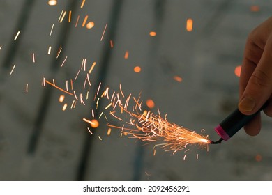 Quemando a Firecracker con Sparks. Hombre sosteniendo una manteca en la mano. Espectáculos de Año Nuevo ruidosos y peligrosos. Hooliganismo con pirotecnia. Ruido de los petardos en lugares públicos