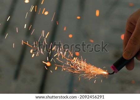 Burning Firecracker with Sparks. Guy Holding a Petard in a Hand. Loud and Dangerous New Year's Entertainment. Hooliganism with Pyrotechnics. Noise of Firecrackers in Public Places