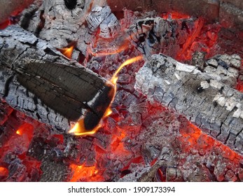 burning firewood and hot coals in an open fireplace