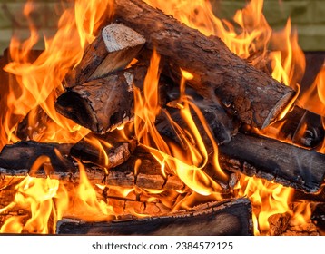 Burning firewood, orange flames filling the frame