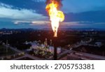 Burning flare stack; dark sky, landscape view