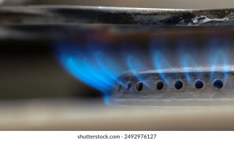 Burning gas stove. Blue flame close-up. blue fire burns natural gas on a kitchen stove. Steel panel with gas burner. natural resources concept, gas price increase, economy - Powered by Shutterstock