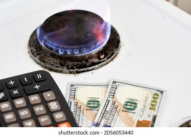 Burning Gas Stove Burner, Calculator And US Dollar Banknotes. Pay For Natural Gas, Bill, Tariff. Pile Of Coins And Burning Fire Gas Stove Hob And Money. Calculating Gas Tariff Or Cost