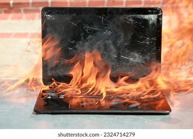 Burning laptop and keyboard, equipment fire due to faulty battery and wiring. Laptop Computer setting the world on fire. Laptop burning in flames. Fire hazard. Losing valuable data. Laptop Damage. 