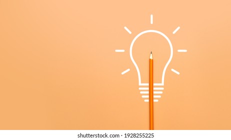 A Burning Light Bulb And A Pencil. A Symbol Of A Difficult Task And The Emergence Of A Creative Idea To Solve It