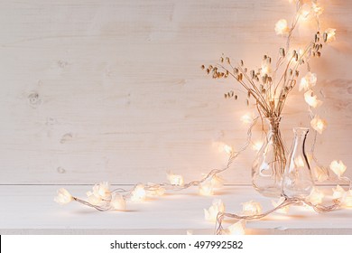 Burning lights and decoration on white wooden background. Interior. - Powered by Shutterstock