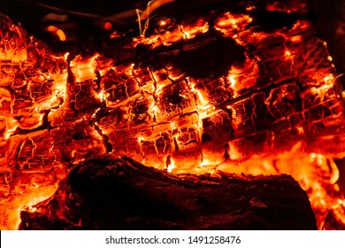 Burning log of wood close-up as abstract background. The hot embers of burning wood log fire. Firewood burning on grill. Texture fire bonfire embers. Smoldering fire - Powered by Shutterstock