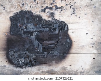 burning mark on wooden desk surface, close-up top view of rustic wood plank floor was charred