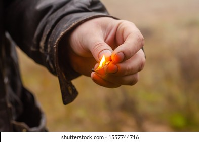 Burning match in the left male hand. A man holds out a dying match to the camera. Shooting at eye level, outdoors. Close-up. Selective focus. - Powered by Shutterstock