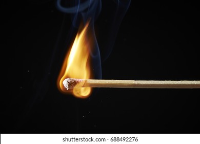 Burning match on black background 