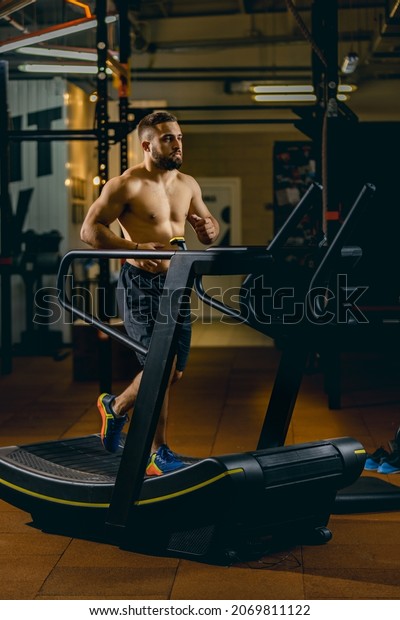 Burning off calories. Maintaining health, motivation.\
Portrait of young sportive man running on a treadmill. Doing\
cardio. Concept of sport, health, action, nutrition. Copy space for\
ad