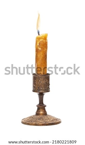 Burning old candle vintage bronze candlestick. Isolated on white background. With clipping path