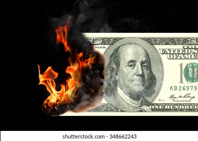 Burning one hundred dollar bill. Black background.
