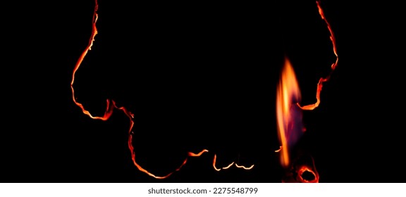 burning paper, glowing edge of paper on a black background