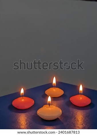 burning pink and white candles at table in night 