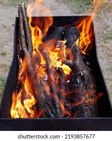 Burning Red Hot Sparks Fly From Fire. Barbecue Gril With Glowing And Flaming Hot Charcoal And Firewood