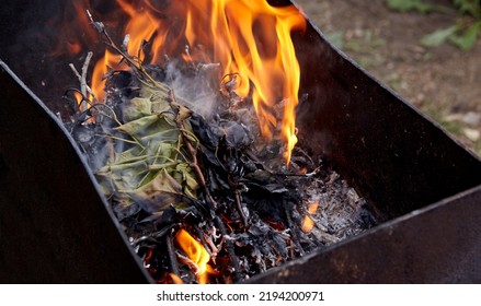 Burning Red Hot Sparks Fly From Fire. Barbecue Gril With Glowing And Flaming Hot Charcoal And Firewood