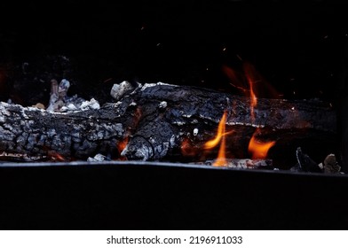 Burning Red Hot Sparks Fly From Fire. Barbecue Gril With Glowing And Flaming Hot Charcoal And Firewood