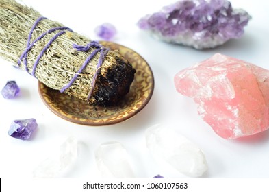 burning sage and crystals on white background