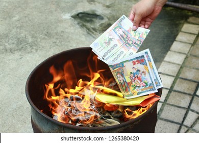 Burning the silver and gold fake money paper for Chinese dead people  ancestors. Joss paper money burning metal bucket dead  in Chinese new year.