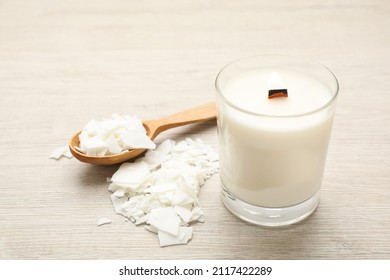 Burning Soy Candle, Wax Flakes And Spoon On Wooden Table