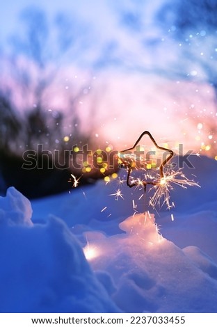 burning sparkler in snow, winter nature abstract background. Christmas and new year holidays. festive winter season. dreams, fantasy, romantic atmosphere image. Hello or goodbye winter concept