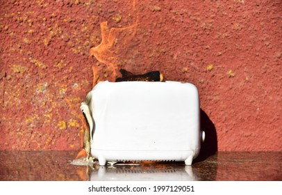 Burning Toaster. Toaster With Toast Caught On Fire Over Table.