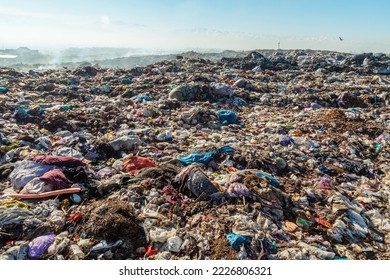 Burning trash piles in landfill with flying crows over the site - Powered by Shutterstock