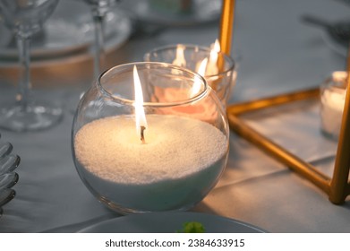 Burning wax candle in a glass cup. - Powered by Shutterstock