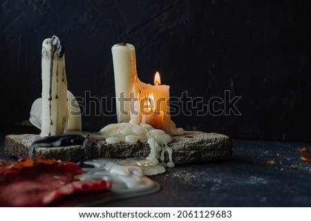 burning wax long candles, melting wax and smoke. a mystical altar. mysterious home decor. halloween mood. selective focus