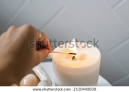 Burning White Candle, alight flames of wick, white candle lit, woman burning match to light candle, lighting flame. 