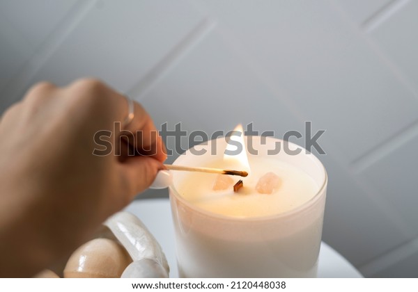 Burning\
White Candle, alight flames of wick, white candle lit, woman\
burning match to light candle, lighting flame.\
