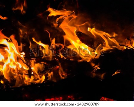 Burning wood at night.Flame and fire sparks on dark abstract background.Hellish fire element. 