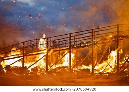 Burning wooden bridge close-up. Raging flames of fire. Firestorm closeup. Wooden structures on fire. Bright inferno flames. Hell fire. Burning constructions background. Intense combustion and heat.