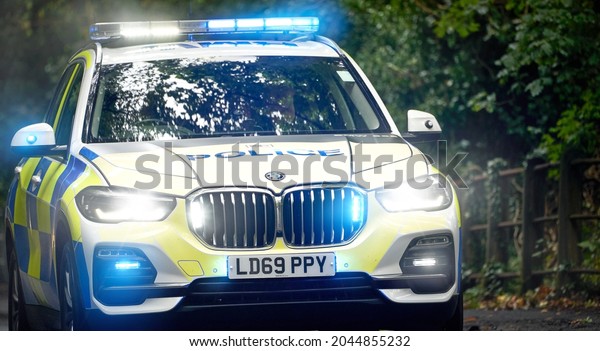 BURNOPFIELD, ENGLAND, UK - SEPTEMBER 10, 2021: The\
flashing blue lights of an emergency police car, vehicle on a\
country road in he\
UK.