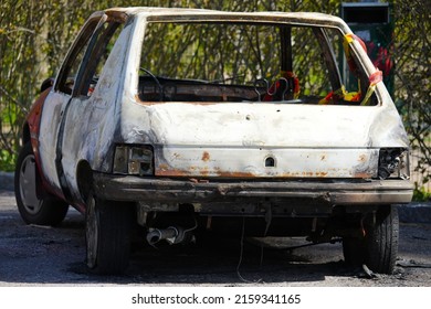 Burnt And Abandoned Car In The Parking Lot. 