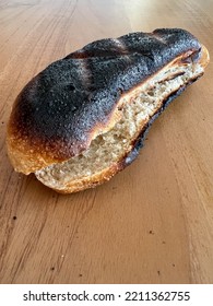 Burnt Bread, Unhealthy Inedible Burnt Loaf Of Sandwich Bread On Wooden Background With Selective Focus And Noise Effects