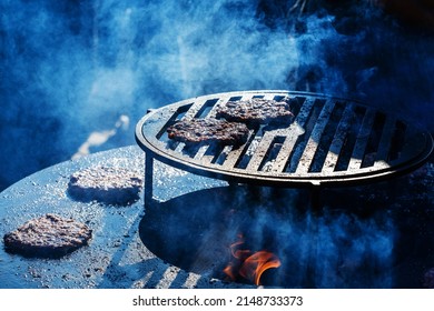 Burnt Burger Patties Are Located On A Metal Grill. Unsuccessful Cooking On Coals And Fire. Selective Focus