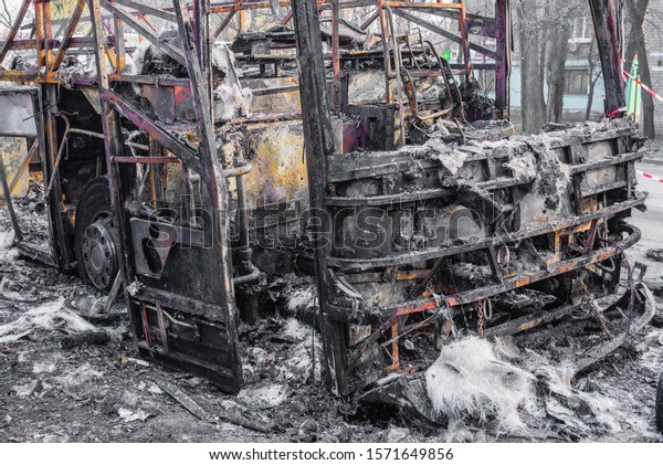 Burnt bus is\
seen on the street after caught in fire during travel, after fire.\
Burned bus at the side of the\
road