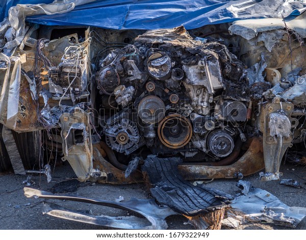 Burnt car hood and broken\
engine