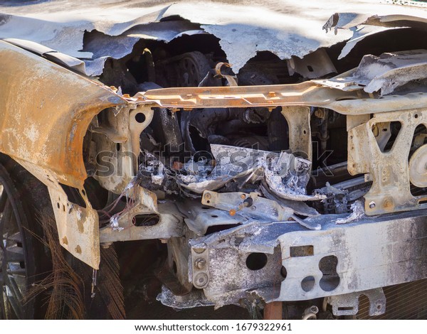 Burnt car hood and broken\
engine